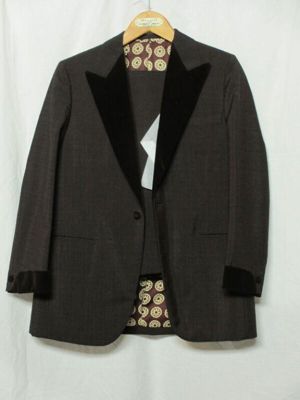 Lord and Stuart, British, 1972. Brown slubbed wool two-piece suit with velvet collar and cuffs; pink cotton shirt and brown grosgrain bow tie by Washington and Tremlett.