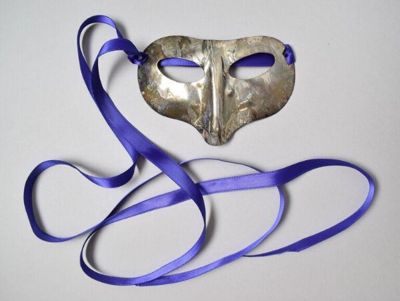 Silver-plate brooch in the shape of a masquerade mask with purple ribbon designed by Patty Glanville for Sheilagh Brown, London, 1980s