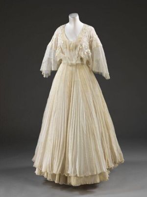 Wedding dress; silk chiffon dress and satin sash with plastic flowers and leaves, net and lace trimmed petticoat, dress cover and hanger, designed by Zandra Rhodes, London, 1976.